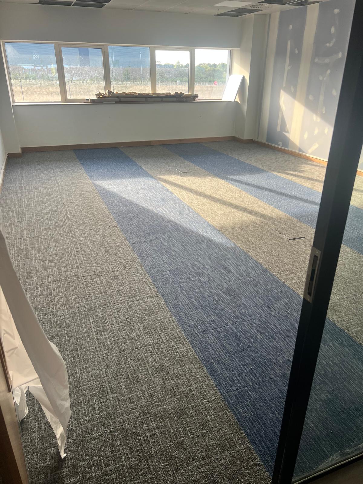 Carpet tile installation in office with contrasting tile stripes