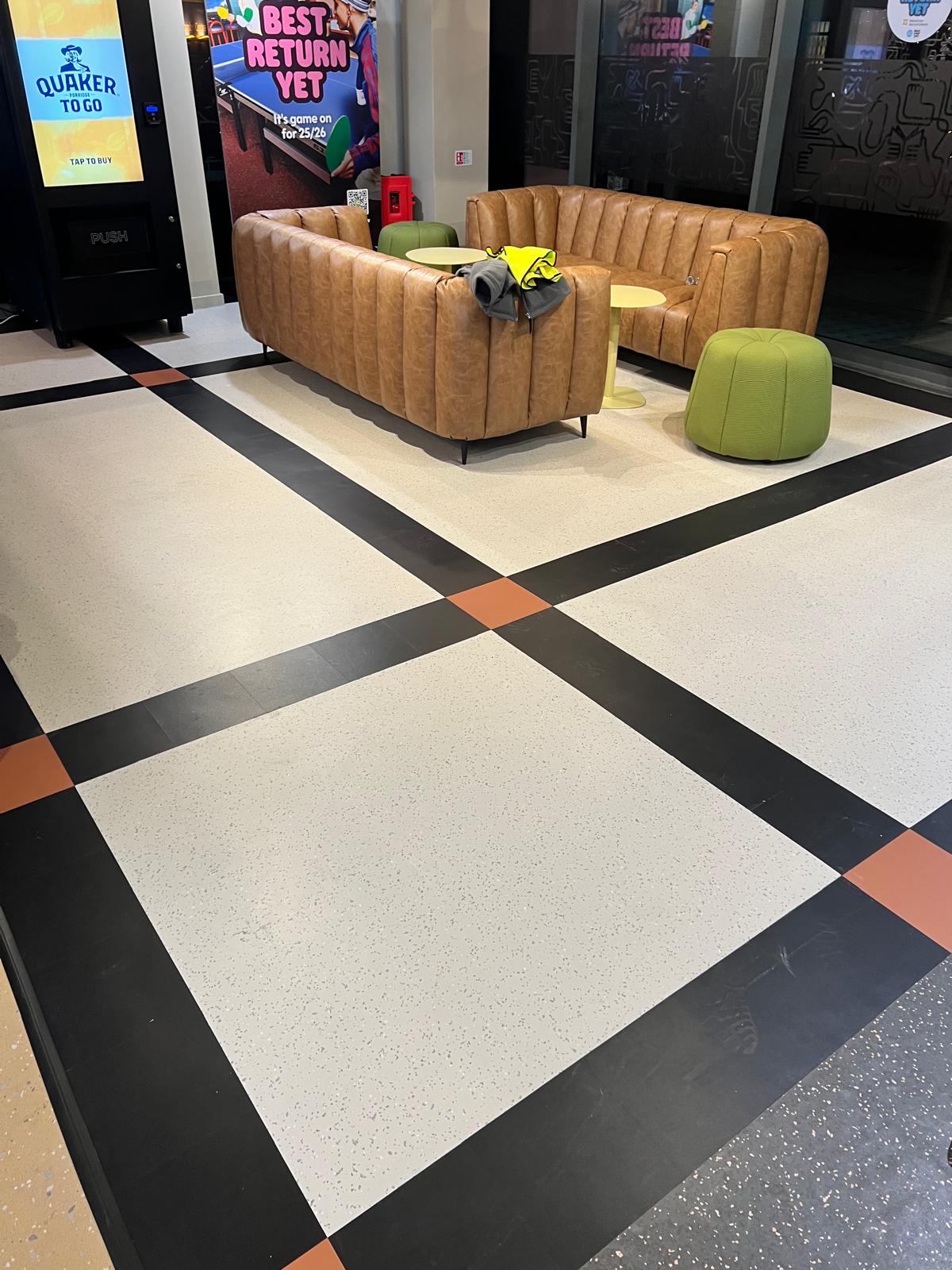 Commercial vinyl floor design with geometric borders in breakout area