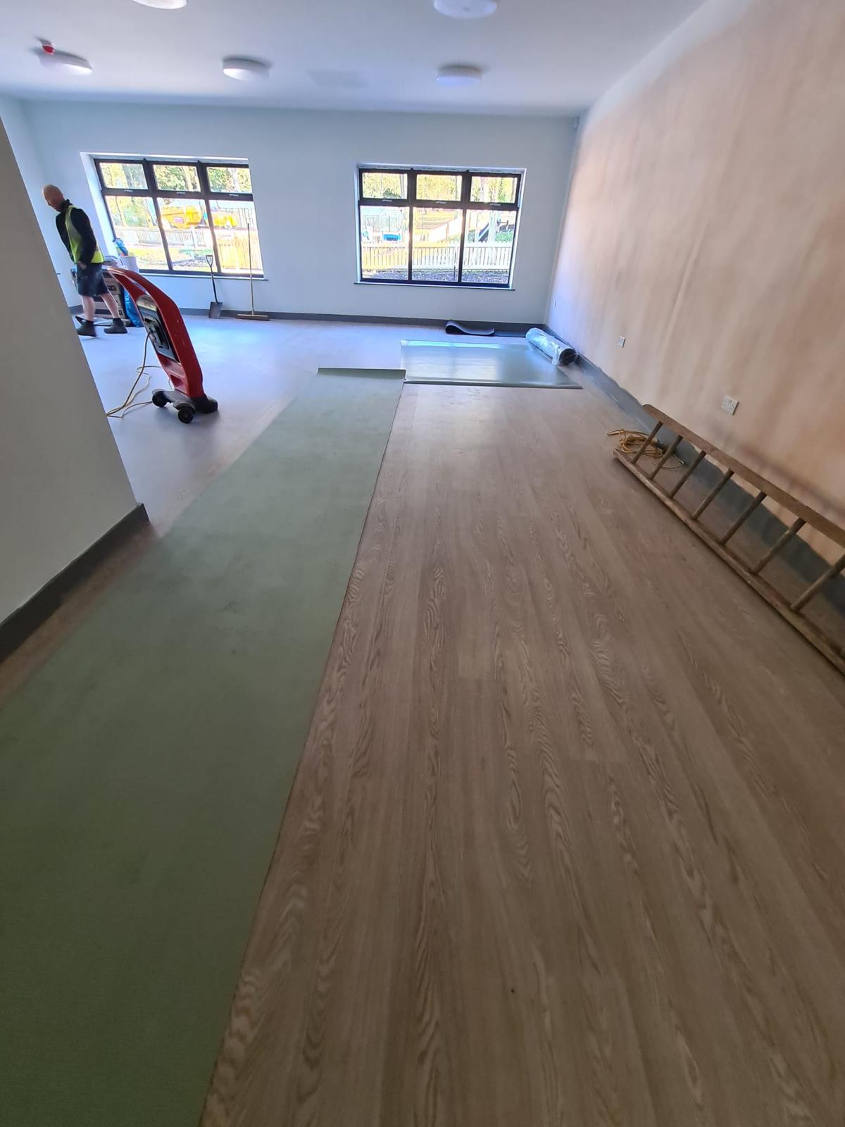 Commercial flooring installation in progress with subfloor and vinyl