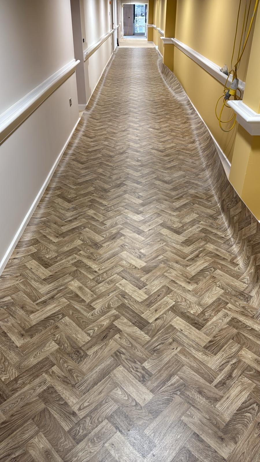Herringbone LVT installation in commercial corridor